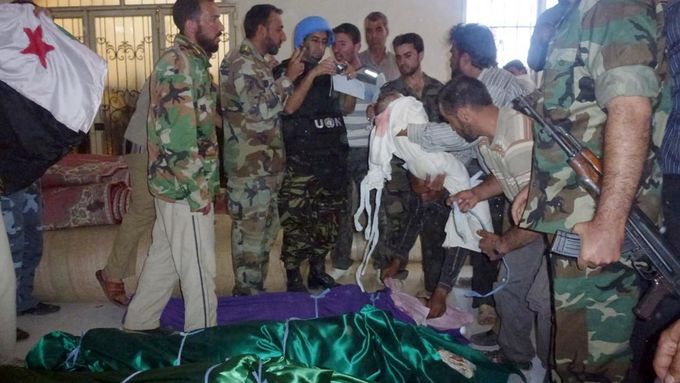 Civilisté ukazují pozorovatelům OSN ostatky dětí.