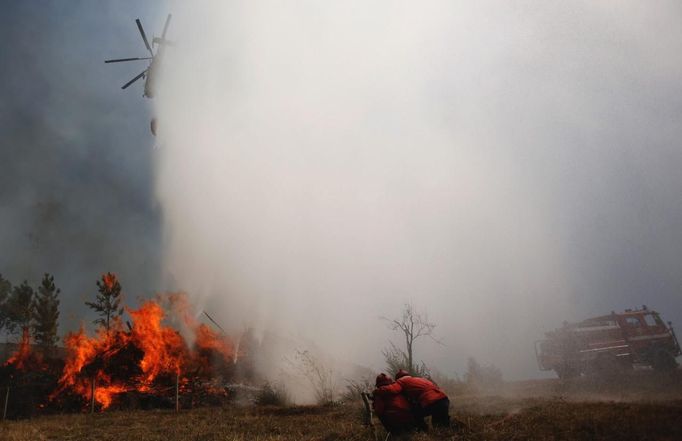 A helicopter drops water over a forest fire in Alvaiazere, near Ourem September 4, 2012. According to the civil defence, over 1,700 firefighters have been mobilized to tackle more than 10 forest fires currently active in Portugal. REUTERS/Rafael Marchante (PORTUGAL - Tags: DISASTER ENVIRONMENT) Published: Zář. 4, 2012, 1:48 odp.