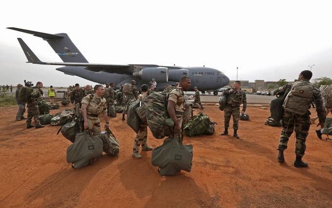 French soldiers carry their equipment after arriving on a US Air Force C-17 transport plane at the airport in Bamako January 22, 2013. The United States has started transporting French soldiers and equipment to Mali as part of its logistical aid to French forces fighting Islamist militants in the north of the country, a U.S. official said on Tuesday. REUTERS/Eric Gaillard (MALI - Tags: CIVIL UNREST CONFLICT MILITARY) Published: Led. 22, 2013, 4:16 odp.