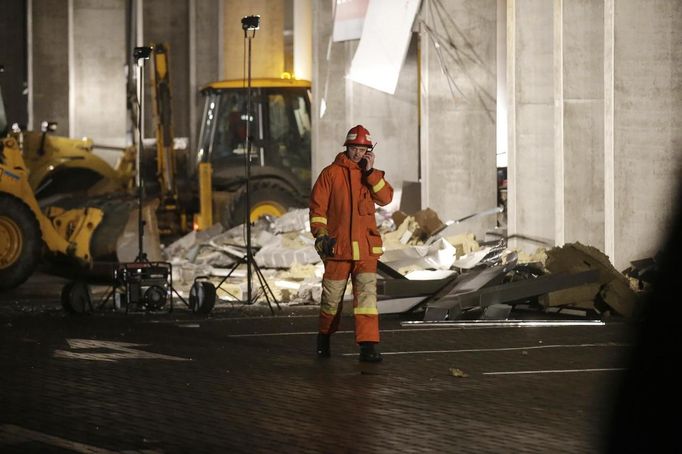 Hasič před troskami zříceného obchodního centra v lotyšské Rize.