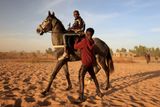 Diop Fallou upravuje sedlo kolegovi během tréninku poblíž senegalského Sangalkamu. "Mnoho z toho, co umíme, nás naučili už doma v rodině, právě tam jsem také získal vášeň pro koně," říká mladý jezdec.