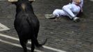 A runner falls in front of Fugado (Runaway), a 545 kg (1200 lb) Cebada Gago fighting bull, on Santo Domingo street during the third Encierro (Running Of The Bulls) at the San Fermin festival in Pamplona July 9, 2012. Three people, two from Britain and one from the U.S. were gored by Fugado (Runaway) after he broke from the pack following a fall in Santo Domingo, in a run that lasted three minutes and thirty-eight seconds. REUTERS/Eloy Alonso (SPAIN - Tags: ANIMALS SOCIETY) Published: Čec. 9, 2012, 9:05 dop.