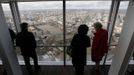 Visitors look out from windows in The View gallery at the Shard in London