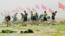 Chinese People's Liberation Army (PLA) soldiers remove algae from a beach near the Olympic Sailing Centre in the city of Qingdao on July 5, 2008. Olympic sailors are not normally afraid of the water, but athletes and coaches say the pollution at the Olympic sailing course in Qingdao makes them very wary of getting wet. The bright green algae that has choked parts of the Olympic course has drawn an unwelcome spotlight on China's environmental record and prompted an ongoing cleanup effort by more than 10,000 people, backed by boats, bulldozers and the military.