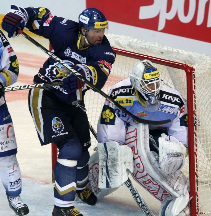 Hokejový brankář Komety Brno Jiří Trvaj hlídá puk před Jaromírem Jágrem v utkání proti Kladnu během 15. kola Tipsport extraligy 2012/13.