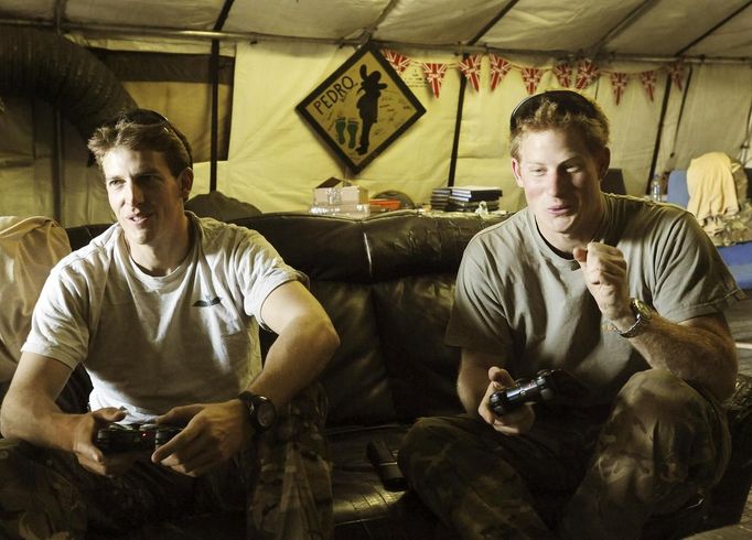 Britain's Prince Harry celebrates after scoring a goal during his computer soccer game with fellow Apache pilot Simon Beattie at Camp Bastion, southern Afghanistan in this photograph taken November 3, 2012, and released January 21, 2013. The Prince, who is serving as a pilot/gunner with 662 Squadron Army Air Corps, is on a posting to Afghanistan that runs from September 2012 to January 2013. Photograph taken November 3, 2012. REUTERS/John Stillwell/Pool (AFGHANISTAN - Tags: MILITARY POLITICS SOCIETY MEDIA ROYALS CONFLICT) Published: Led. 21, 2013, 9 odp.