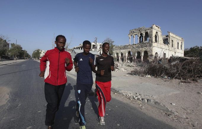 Somali athletes run along a ruined street as they train during preparations for the 2012 London Olympic Games in Somalia's capital Mogadishu, March 14, 2012. Picture taken March 14, 2012 file photo. Training in a bullet-riddled stadium where the remains of a rocket propelled grenade lies discarded on the track's edge counts as progress for Somali Olympic hopeful Mohamed Hassan Mohamed. A year ago, Mogadishu's Konis stadium was a base for Islamist militants and a work out meant at times running through the streets, dodging gun-fire and mortar shells in one of the world's most dangerous cities. To match OLY-SOMALIA-HOPES/ REUTERS/Feisal Omar/Files (SOMALIA - Tags: SPORT ATHLETICS SOCIETY OLYMPICS) Published: Čer. 11, 2012, 7:01 dop.