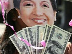 Demonstrantka s maskou prezidentky Arroyové a dolarovými bankovkami symbolizujícími korupci. V posledních dnech před budovou filipínského Senátu běžný výjev