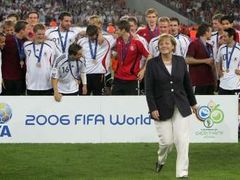 Fotbalisté Německa s bronzovými medailemi. Vpředu kráčí kancléřka Angela Merkelová.
