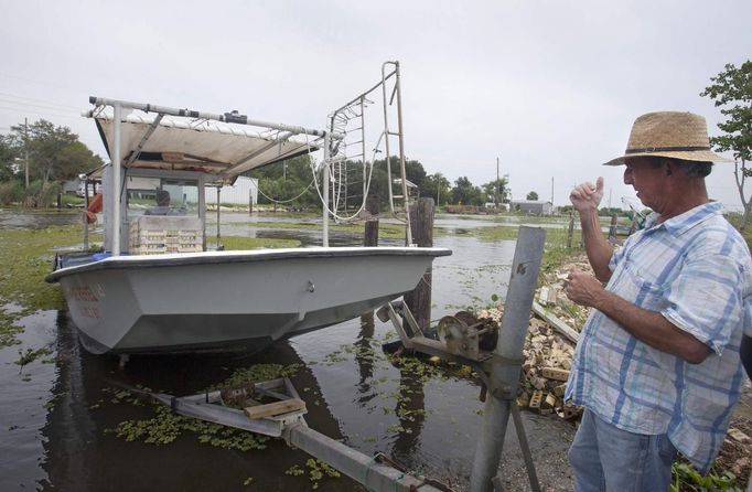 Perry Marie (R) helps his brother Roy pull his crabbing boat out of a bayou as they prepare for the arrival of Tropical Storm Isaac in Chauvin, Louisiana August 27, 2012. Tropical Storm Isaac closed in on the U.S. Gulf of Mexico coast on Monday, triggering some mandatory evacuation orders and disrupting U.S. offshore oil production as it threatened to make landfall between Florida and Louisiana as a full-blown hurricane. REUTERS/Lee Celano (UNITED STATES - Tags: ENVIRONMENT) Published: Srp. 27, 2012, 9:57 odp.