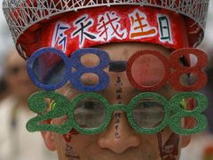 Žena s účesem do tvaru olympijských kruhů krátce před zahájením olympijských her v Pekingu.