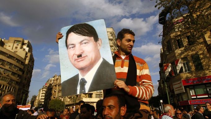 Demonstrant nese plakát s Mubarakem, upraveným jako Hitler.
