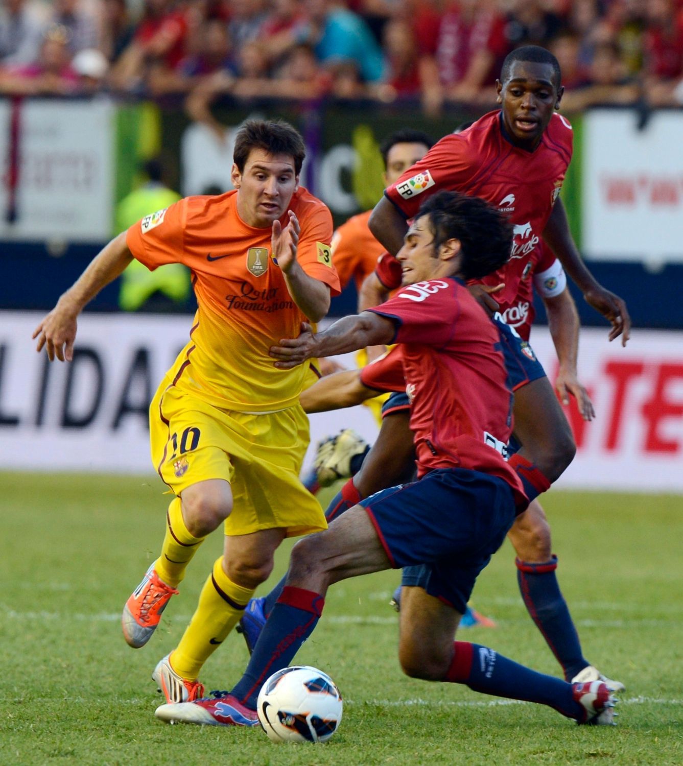 Fotbalista Barcelony Lionel Messi je faulován Alejandrem Arribasem v utkání La Ligy 2012/13 s Osasunou.