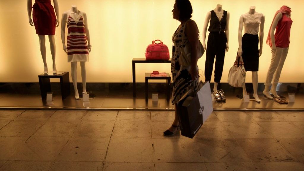 Žena se dívá do výkladní skříně v obchodní pasáži v centru Atén. Řecká ekonomika v letošním roce poklesne o více než 4,5 procenta.