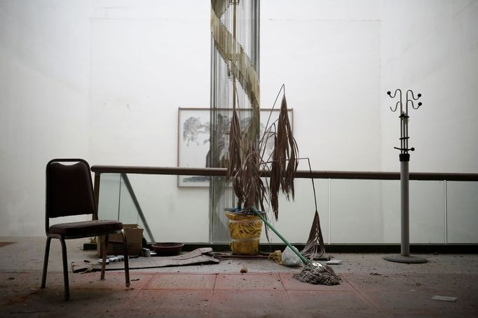 A chair, a broom and a hanger stand in the main hall of the abandoned Alps Ski Resort