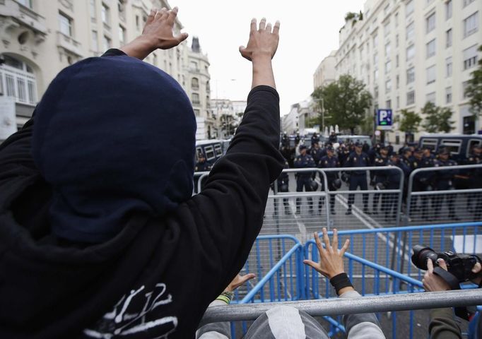 Anti-austerity demonstrators gesture over a barrier at police outside the the Spanish parliament in Madrid, September 25, 2012. Protesters clashed with police in Spain's capital on Tuesday as the government prepared a new round of unpopular austerity measures for the 2013 budget to be announced on Thursday. REUTERS/Paul Hanna (SPAIN - Tags: POLITICS CIVIL UNREST BUSINESS) Published: Zář. 25, 2012, 11:31 odp.