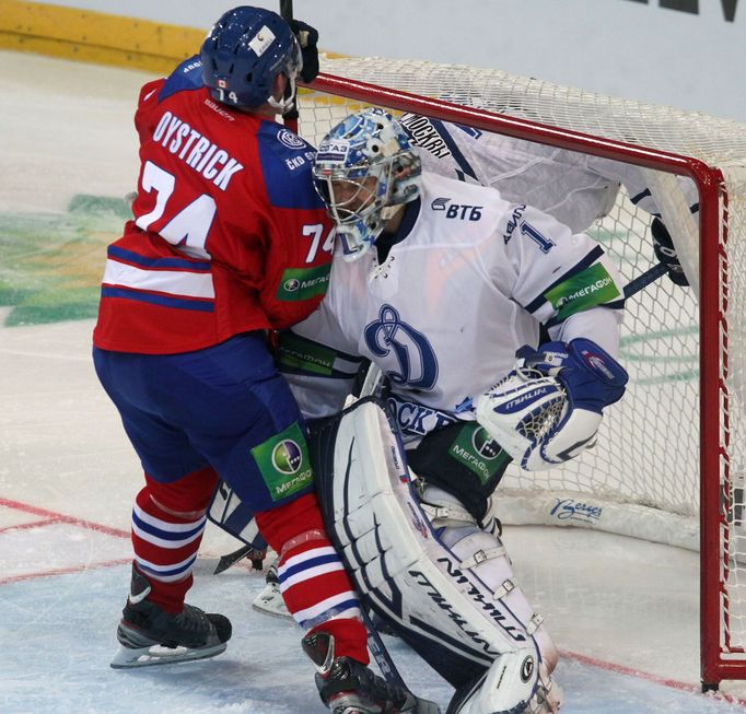 Hokejový brankář Dynama Moskva Alexandr Jerjomenko se sráží s Nathanem Oystrickem v utkání KHL 2012/13 proti Lvu Praha.