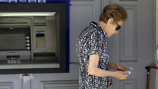 Řecké banky jsou zavřené už druhým týdnem. Tato žena měla štěstí, v bankomatu byly peníze.