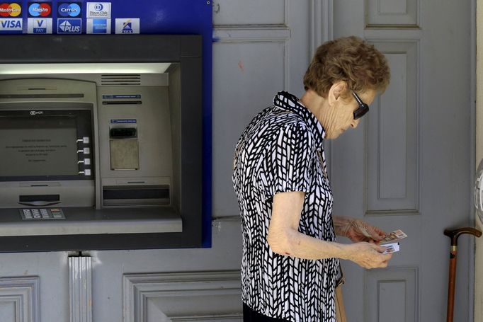 Řecké banky jsou zavřené už druhým týdnem. Tato žena měla štěstí, v bankomatu byly peníze.