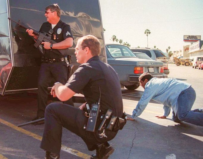 Policejní zásahové složky se kryjí za automobily během přestřelky s bankovními lupiči v Los Angeles v USA. 28. 2. 1997.