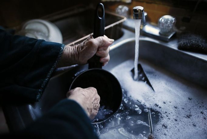 Mary Herring, 78, washes dishes in her trailer in which she has lived for 20 years, in Village Trailer Park in Santa Monica, California, July 12, 2012. Developer Marc Luzzatto wants to relocate residents from the trailer park to make way for nearly 500 residences, office space, stores, cafes and yoga studios, close to where a light rail line is being built to connect downtown Los Angeles to the ocean. Village Trailer Park was built in 1951, and 90 percent of its residents are elderly, disabled or both, according to the Legal Aid Society. Many have lived there for decades in old trailers which they bought. The property is valued at as much as $30 million, according the LA Times. Picture taken July 12, 2012. REUTERS/Lucy Nicholson (UNITED STATES - Tags: POLITICS REAL ESTATE BUSINESS SOCIETY) Published: Čec. 14, 2012, 6:44 dop.