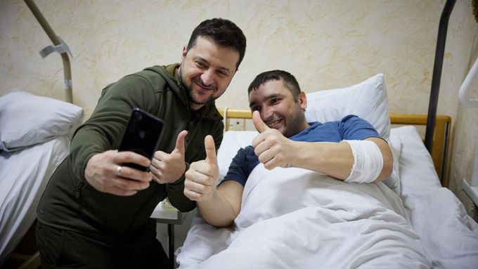 Volodymyr Zelenskyj se zraněným ukrajinským vojákem v nemocnici.