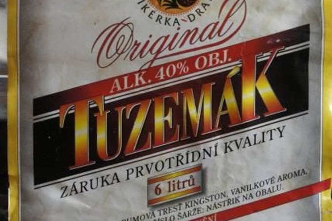 Etiketa Tuzemáku v plastovém barelu. Policie před ním varuje. Jako výrobce uvedena Likérka Drak.