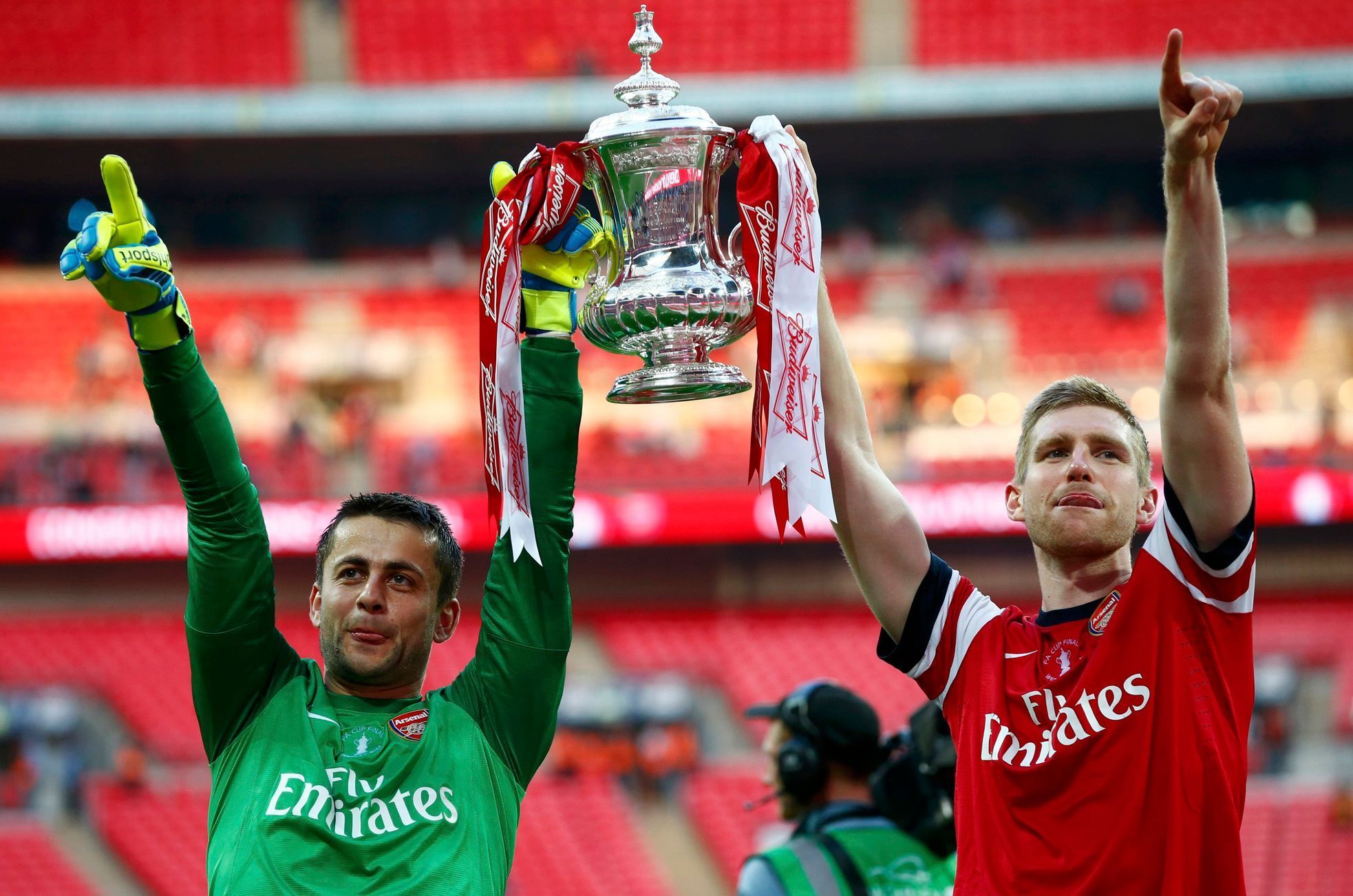 Arsenal's goalkeeper Fabianski and Mertesacker lift the trophy to celebrate their victory against Hull City in their FA Cup final at Wembley Stadium in London