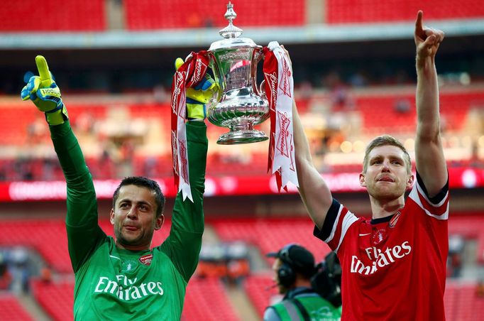 Arsenal's goalkeeper Fabianski and Mertesacker lift the trophy to celebrate their victory against Hull City in their FA Cup final at Wembley Stadium in London