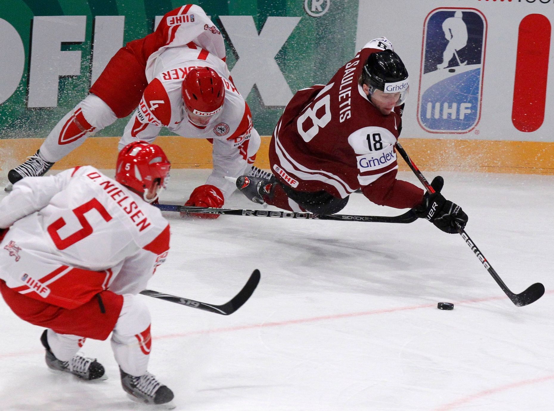Saulietis bojuje o puk s D.Nielsenem a Bodkerem v zápase Lotyšsko - Dánsko