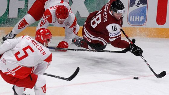 Saulietis bojuje o puk s D.Nielsenem a Bodkerem v zápase Lotyšsko - Dánsko.