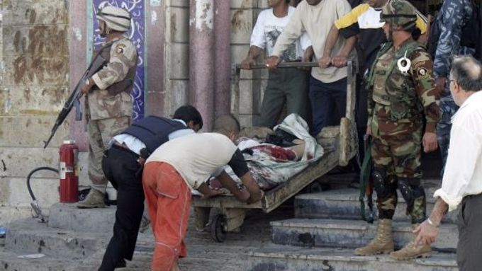 Lidé odvážejí mrtvé tělo, které zabil sebevraždedný výbuch v šíitské mešitě ve středu Bagdádu