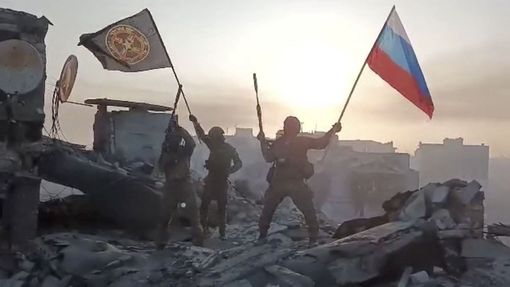 Ruští žoldnéři Wagnerovci vztyčují svou vlajku v Bachmutu.