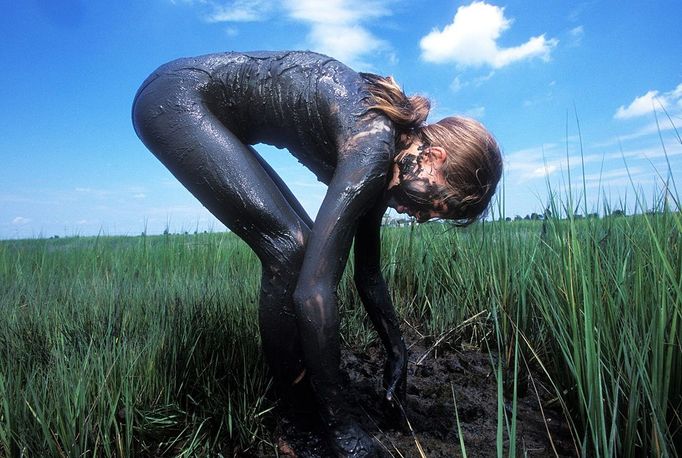 STONE HARBOR, NJ - JULY 11: Covered in mud and hunting for snails, a student participating in a summer Wetlands Institute program to teach kids about wildlife and plant life in and around the wetlands July 11, 2003 in Stone Harbor, New Jersey. The Jersey Shore, a 127 mile stretch of coastline known for its variety of beaches, boardwalks, small towns, natural beauty and summer crowds, has been a popular summer destination for over a century.