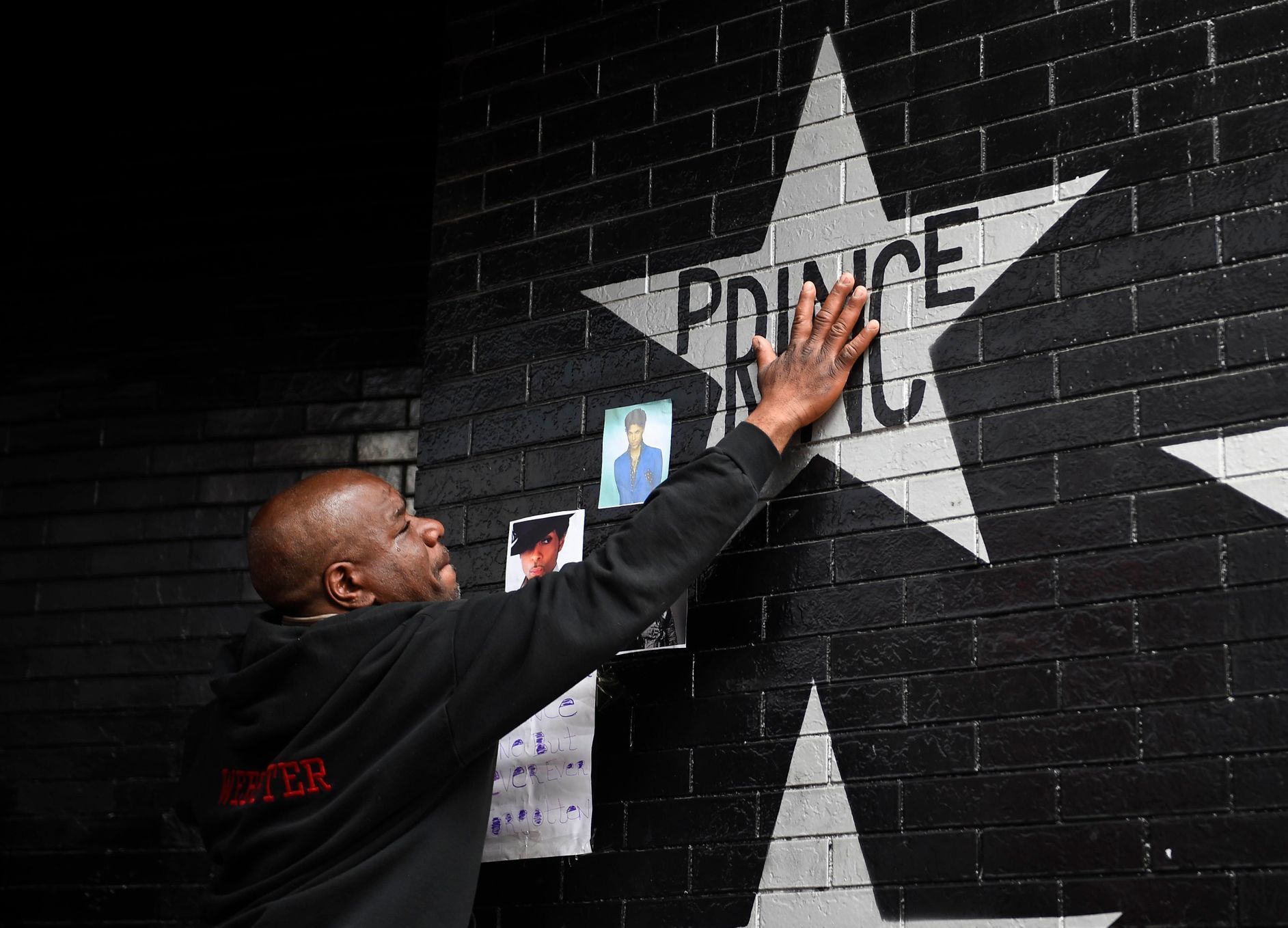 Donnie Straub of Minneapolis touches a star bearing U.S. music superstar Prince's name on an exterior wall of First Avenue in Minneapolis Minnesota