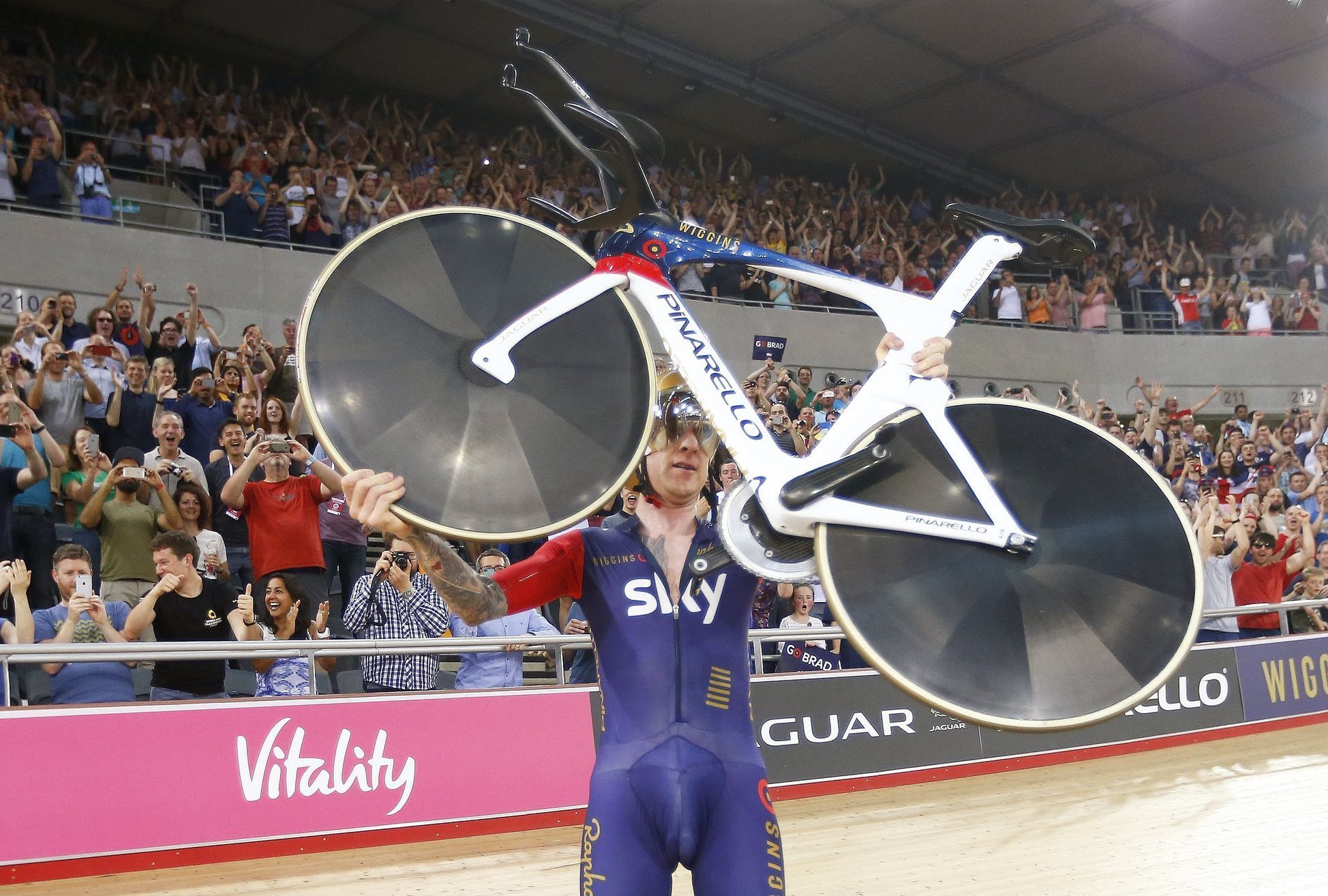 Bradley Wiggins picks up his bicycle as he celebrates after breaking cycling's hour record at the Olympic velodrome in East London, Britain