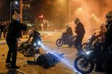 Za uplynulý rok proběhla celá řada velkých protestů. Na tomto snímku fotograf agentury Reuters v březnu zachytil, jak policisté na motocyklech obklopili zraněného kolegu během demonstrace v řeckých Athénách. Lidé tehdy protestovali proti zákazu shromažďování.