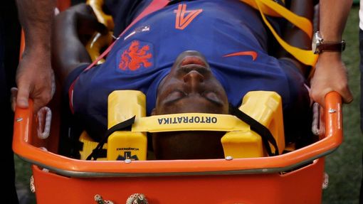 Bruno Martins Indi of the Netherlands is carried in a stretcher after being fouled by Australia's Tim Cahill during their 2014 World Cup Group B soccer match at the Beira