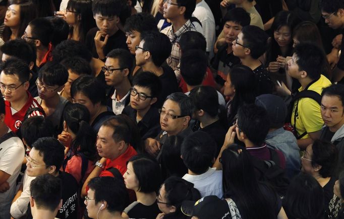 Customers gather outside an Apple store before the release of iPhone 5 in Hong Kong September 21, 2012. Apple Inc's iPhone 5 hit stores around the globe on Friday, with fans snapping up the device that is expected to fuel a huge holiday quarter for the consumer giant. REUTERS/Bobby Yip (CHINA - Tags: BUSINESS SCIENCE TECHNOLOGY) Published: Zář. 21, 2012, 2:47 dop.