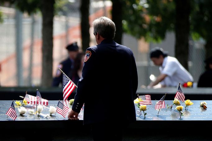 Člen newyorských hasičů se dívá na jména na pomníku během obřadu k 15. výročí útoků na Světové obchodní centrum v New Yorku.