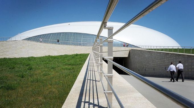 People walk outside the Bolshoi Ice Dome arena - ice hockey venue at the Olympic Park in Adler outside Sochi, during the IIHF U18 International Ice Hockey World Championship on April 28, 2013.