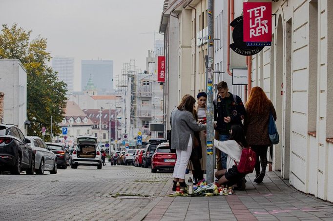 Před gay barem Tepláreň, kde byli zastřeleni dva muži lidé pokládají květiny a zapalují svíčky.