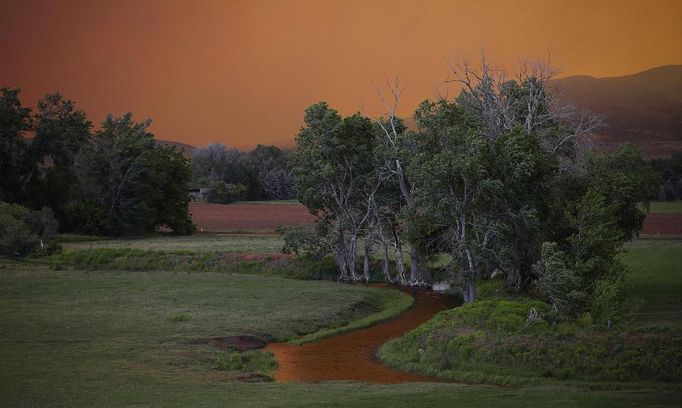 The sky turns a brilliant orange as smoke from the High Park Fire fills the sky near Laporte, Colorado June 10, 2012. The fire started on Saturday and was estimated at more than 14,000 acres on Sunday morning. At least 18 structures were lost or damaged due to the fire with more threatened and officials are searching for one person believed to be missing. The cause of the fire is unknown and it remains at zero percent containment. REUTERS/Marc Piscotty (UNITED STATES - Tags: DISASTER ENVIRONMENT) Published: Čer. 10, 2012, 11:51 odp.