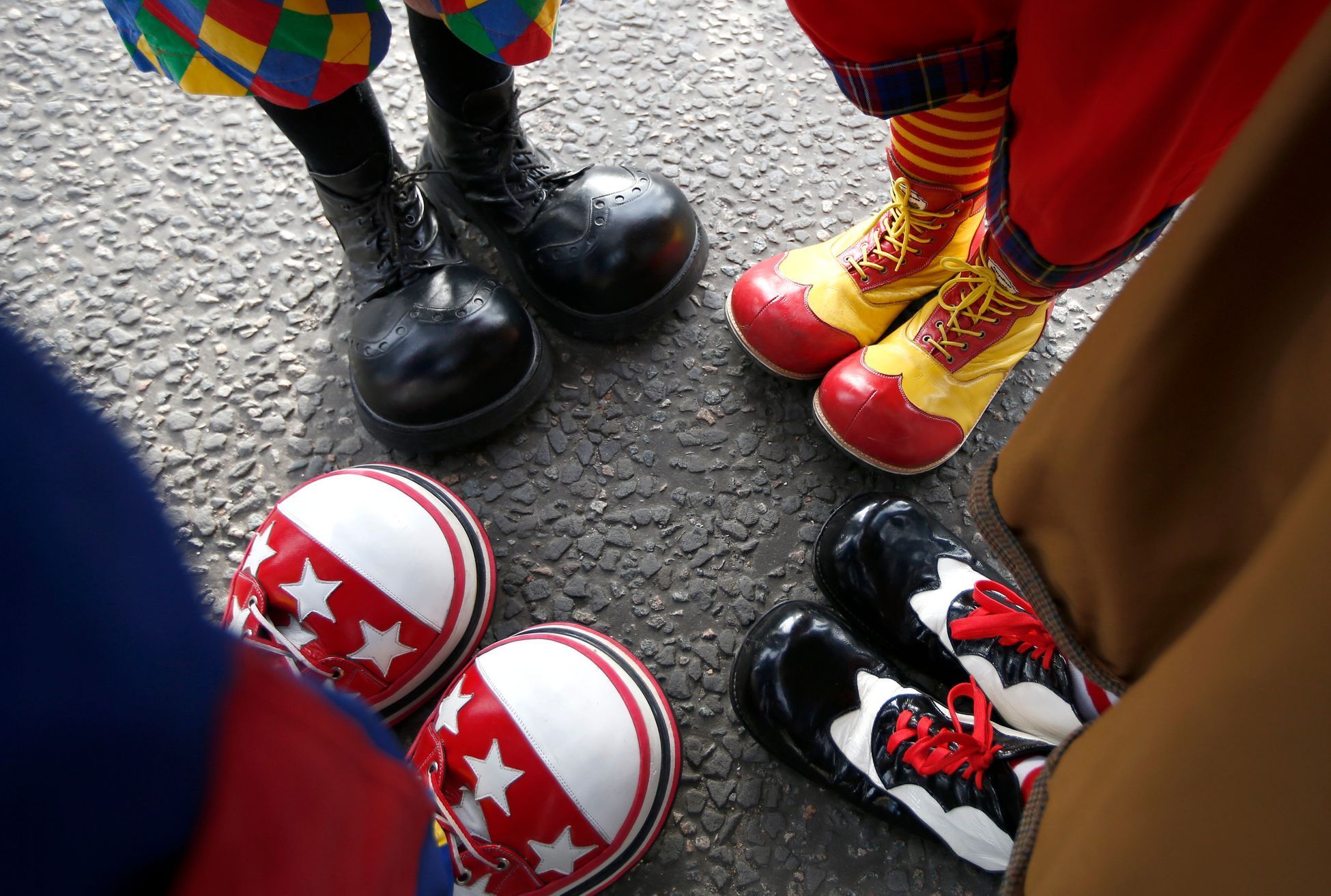Clowns stand together as they compare their shoes outside the All Saints Church before the Grimaldi clown service in Dalston, north London