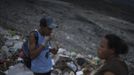 A garbage collector eats food found at the municipal dump site in Tegucigalpa