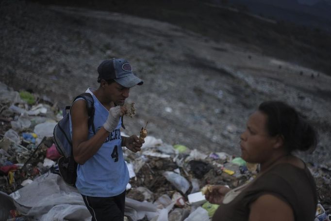 A garbage collector eats food found at the municipal dump site in Tegucigalpa