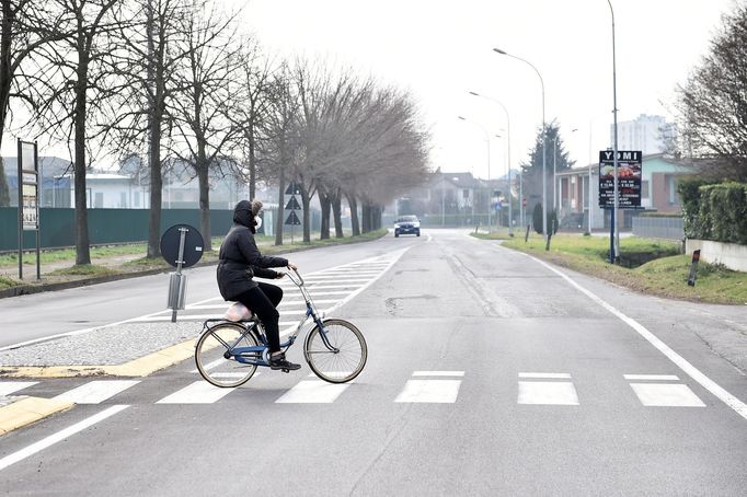 Muž s rouškou na kole v ulicích města Codogno.