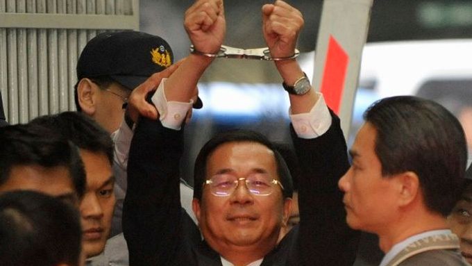 Čchen Šuej-pien ukazuje své spoutané ruce novinářům