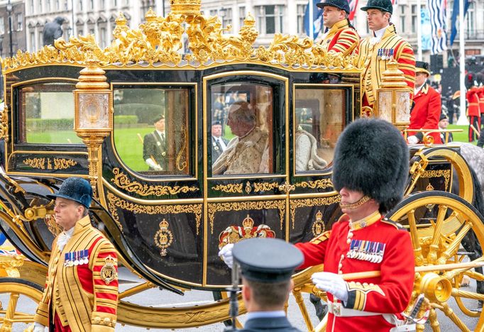 Král Karel III. a královna Camilla v kočáře. Královský průvod projíždí Parlamentním náměstím na korunovaci.