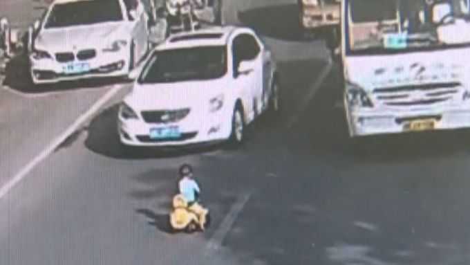 V čínském městě Li-šuej se asi tříleté dítě vydalo v ranní špičce na odrážedle proti jedoucím autům. Policista ho zachránil a předal matce.